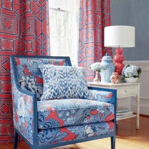 Bright floral armchair with blue and coral upholstery in a stylish home interior.