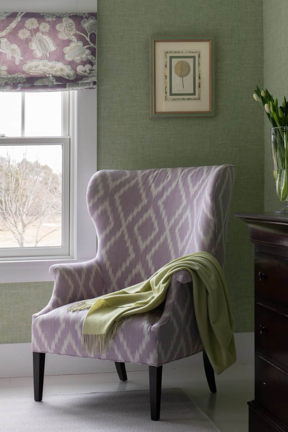 Elegant wingback chair with soft purple and white upholstery in cozy corner.